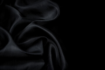 Part of the dark fabric texture of the fabric for the background and decoration of the work of art, a beautiful crumpled pattern of silk or linen. A crumpled piece of cloth
