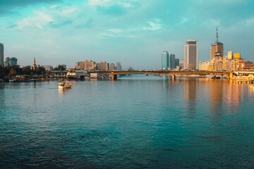 Cairo Egypt December 2021 View of the amazing Nile river at sunrise, boats anchored on the shores. Bright blue river and sky colors. Skyscrappers in the distance