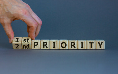 1st or 2nd priority symbol. Businessman turns wooden cubes and changes words 2nd priority to 1st...