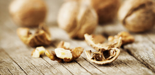 Fresh cracked nuts, kernels and shells on the table, healthy food brown banner