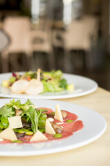 TTenderloin carpaccio with parmesan cheese and salad. Raw meat