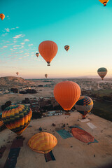 Vertical shot of many balloons taking off and preparing for take off in luxor egypt. Amazing view of the surrounding area at sunrise - obrazy, fototapety, plakaty
