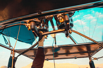 Close view of the propane burner torch on an air balloon. Pilots hand on the lever used for piloting the air balloon