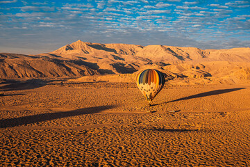 View of a single hot air balloon in luxor egypt landing in a random spot at the end of the ride....