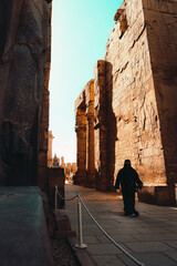 Luxor Egypt January 2022 Vertical shot of the entrance to the luxor temple in egypt. Woman walking between the massive ancient stone pillars