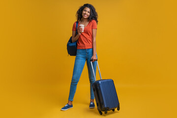 Full-length studio portrait of happy smiling attractive tourist woman wearing travel backpack and...