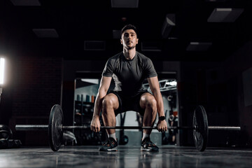 Obraz na płótnie Canvas A strong man practicing bodybuilding at the gym.
