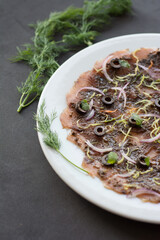 Sliced ​​fish. Fish carpaccio with salad, olives and fennel