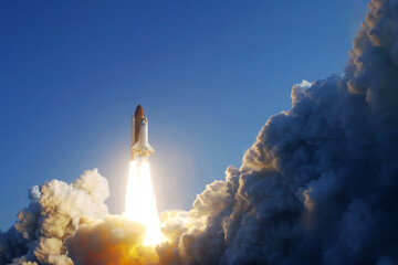 Take off space rocket on a background of blue sky and sun. Elements of this image were furnished by...