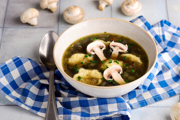 Mushroom broth with dumplings and champignons