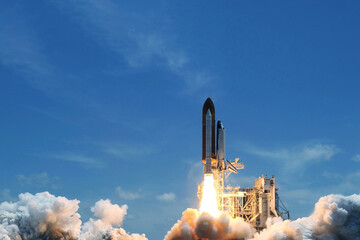 Take off space rocket on a background of blue sky and sun. Elements of this image were furnished by...