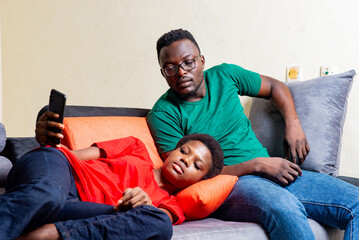beautiful young couple sitting together on a sofa at home.