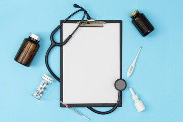 Obraz na płótnie Canvas A tablet with a blank page on a blue background. Medical diagnosis or a mock-up of a doctor's prescription.