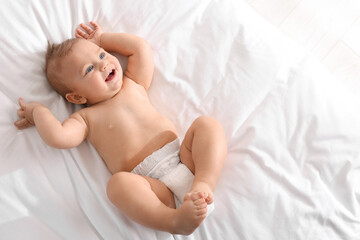 Cute little baby lying on bed, top view. Space for text