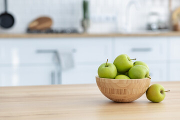Fresh green apples in a wooden bowl on a wooden table witj copy space. Healthy eating
