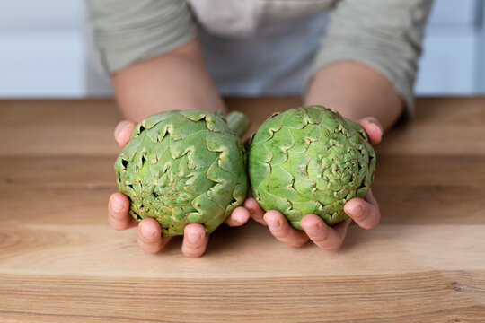 Artichauts dans une cuisine en gros plan avec mains de femme