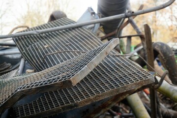 Alte ausgediente gewölbte Schachtgitter auf Schrotthaufen auf Baustelle im Winter