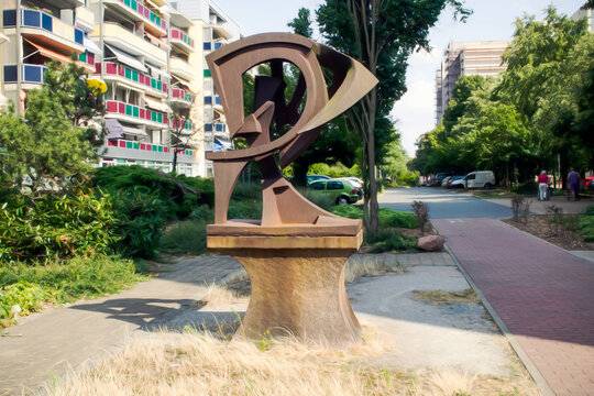 RIESA/GERMANY - July 23/2018: Artistic realistic illustration of cityscape with houses, asphalt road, .old rusty monument in the form of letter R and trees