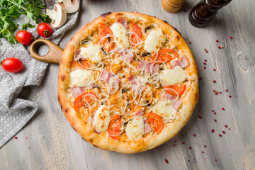 Italian meat pizza with onion and cheese on grey wooden table top view