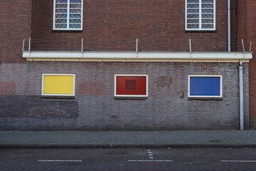 Brick Building Facade with Yellow, Red and Blue Details in Amsterdam, Netherlands
