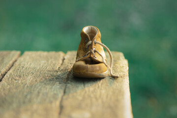 children's old lost yellow leather shoe stand on bench on blurry background