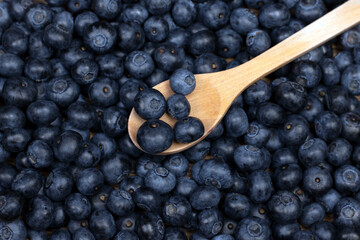 Blueberry background. Ripe berries background with wooden spoon.
