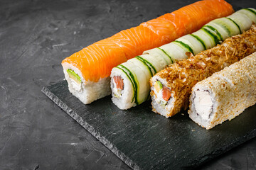 appetizing set of sushi roll on a black stone plate