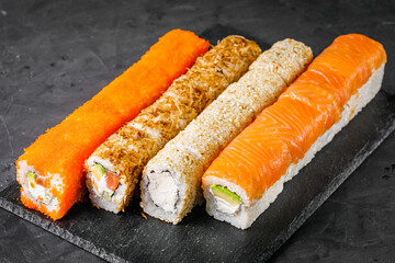 appetizing set of sushi roll on a black stone plate