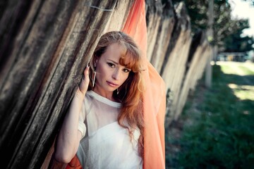 red-haired girl in a white dress with long hair in the forest