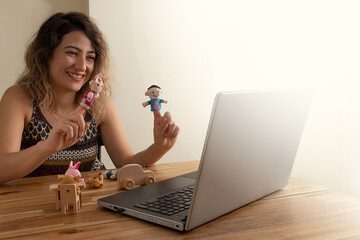 Pre school teacher performing game therapy to the students on internet. Online education concept.