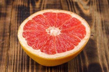 Cut grapefruit half on wooden table.