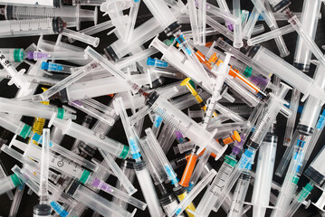 many used medical syringes with needles. Medical garbage. Medical waste. Raw materials for...