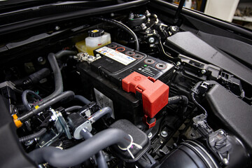 Plakat car battery under the hood of the car