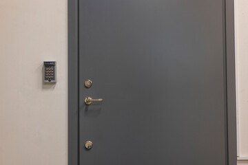 Close up view of a gray extra heavy metal door with an electronic combination lock. Sweden.