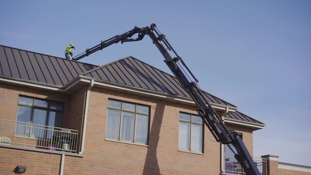 Roofing Materials Being Lifted To The Rooftop Of A Commercial Building