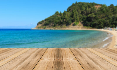 Fondo de playa desenfocado con tabla de mesa en primer plano. Paisaje y mesa. Tablón y fondo de playa. Naturaleza.