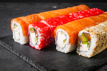 appetizing set of sushi roll on a black stone plate