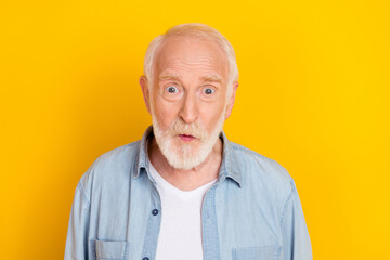 Portrait of attractive amazed cheerful funky grey-haired man incredible news omg isolated over bright yellow color background