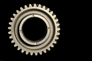 Cog wheel on a black background. Auto parts.