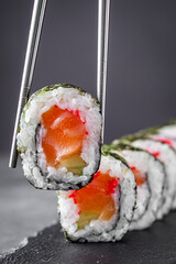 appetizing sushi roll maki with salmon on a black stone plate