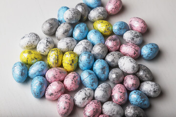 Little colored easter eggs on a white table.