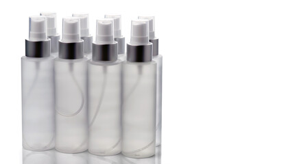 Transparent spray bottles with liquid isolated on a white background.