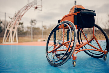 Sports wheelchair on an outdoor basketball court.