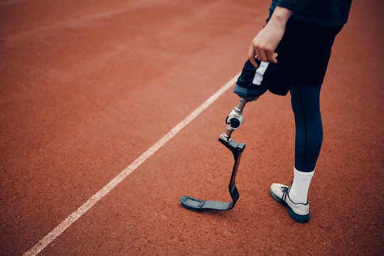 Unrecognizable athletic man with artificial leg on running track at the stadium.