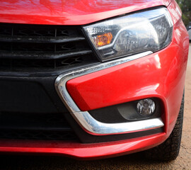 Fototapeta premium Part of the front of a red car as a background, close shot, Russian model