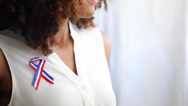 dominican woman with curly hair on the window smiling with dominican flag
