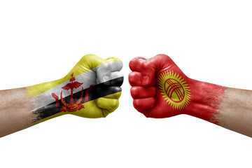 Two hands punch to each others on white background. Country flags painted fists, conflict crisis concept between brunei and kyrgyzstan