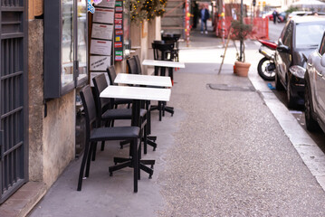 Tables of an outdoor cafe. Spring street of Rome. The sidewalk on which there are tables and chairs for visitors.