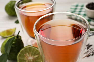 Glass cups of tasty bergamot tea on table, closeup
