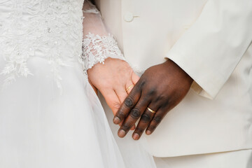 Causian and African couple holding hand with ring